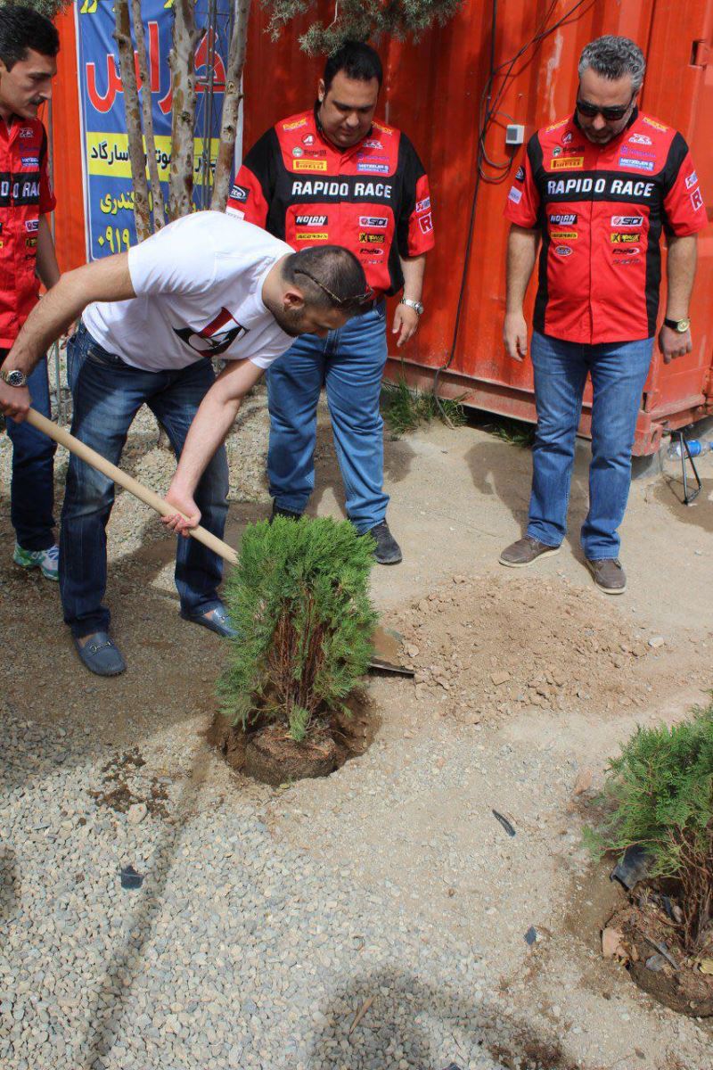 آقای مسعود غلامی مدیر عامل نیکران موتور در حال کندن زمین با بیل برای کاشت درخت در زمین